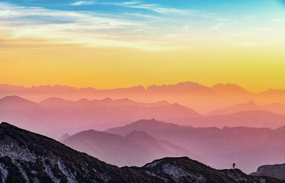 Hiker ascending mountain into a state of health and wellness.