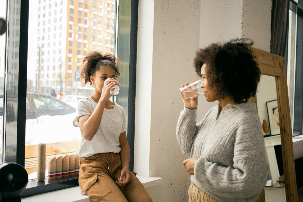 Two young women drinking water.